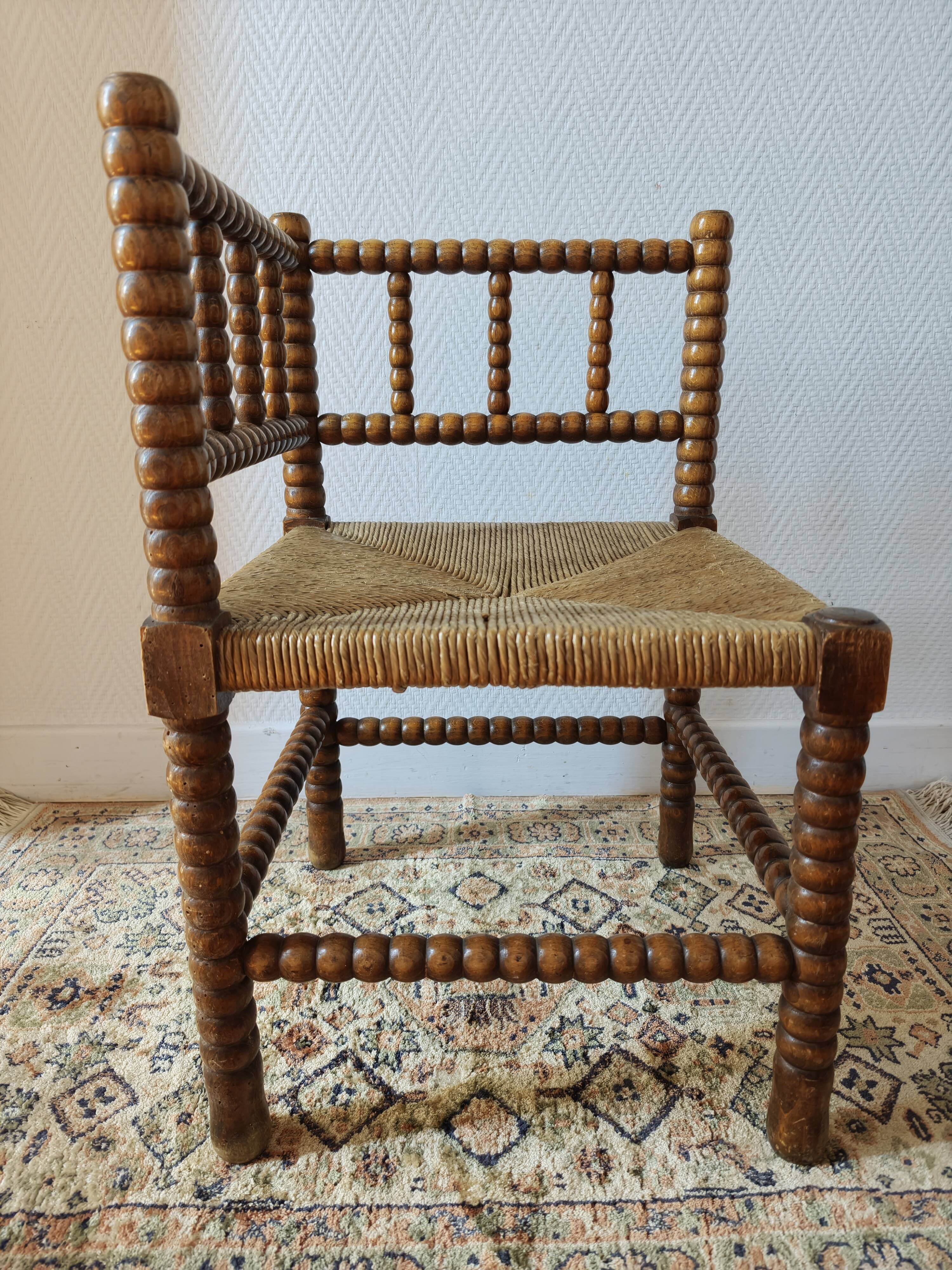 Antique corner chair by the fire with turned wood and straw seat.