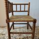 Antique corner chair by the fire with turned wood and straw seat.