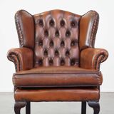 Very beautiful, stately, cowhide Chesterfield wing chair with elegant legs in a nice brown color