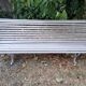Pair of antique wooden slatted benches with wrought iron legs.