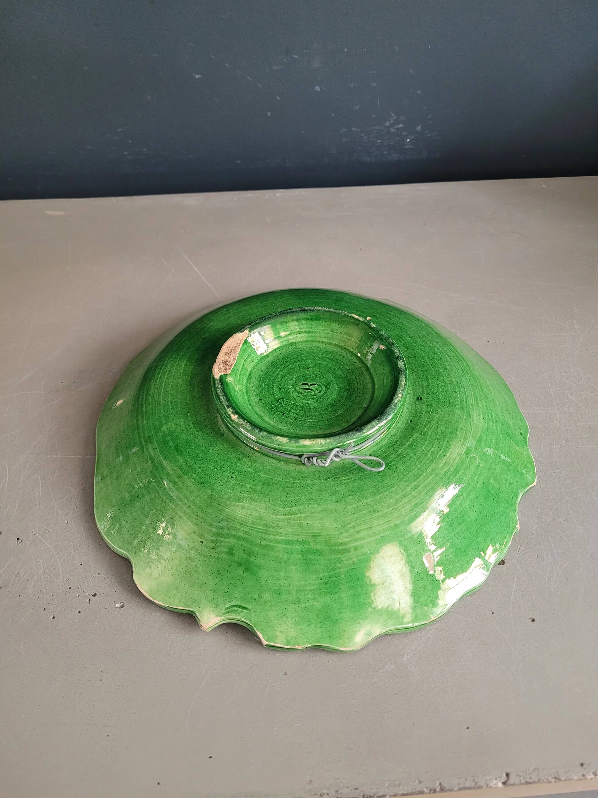 Plate decorated with a sunflower motif in slipware.