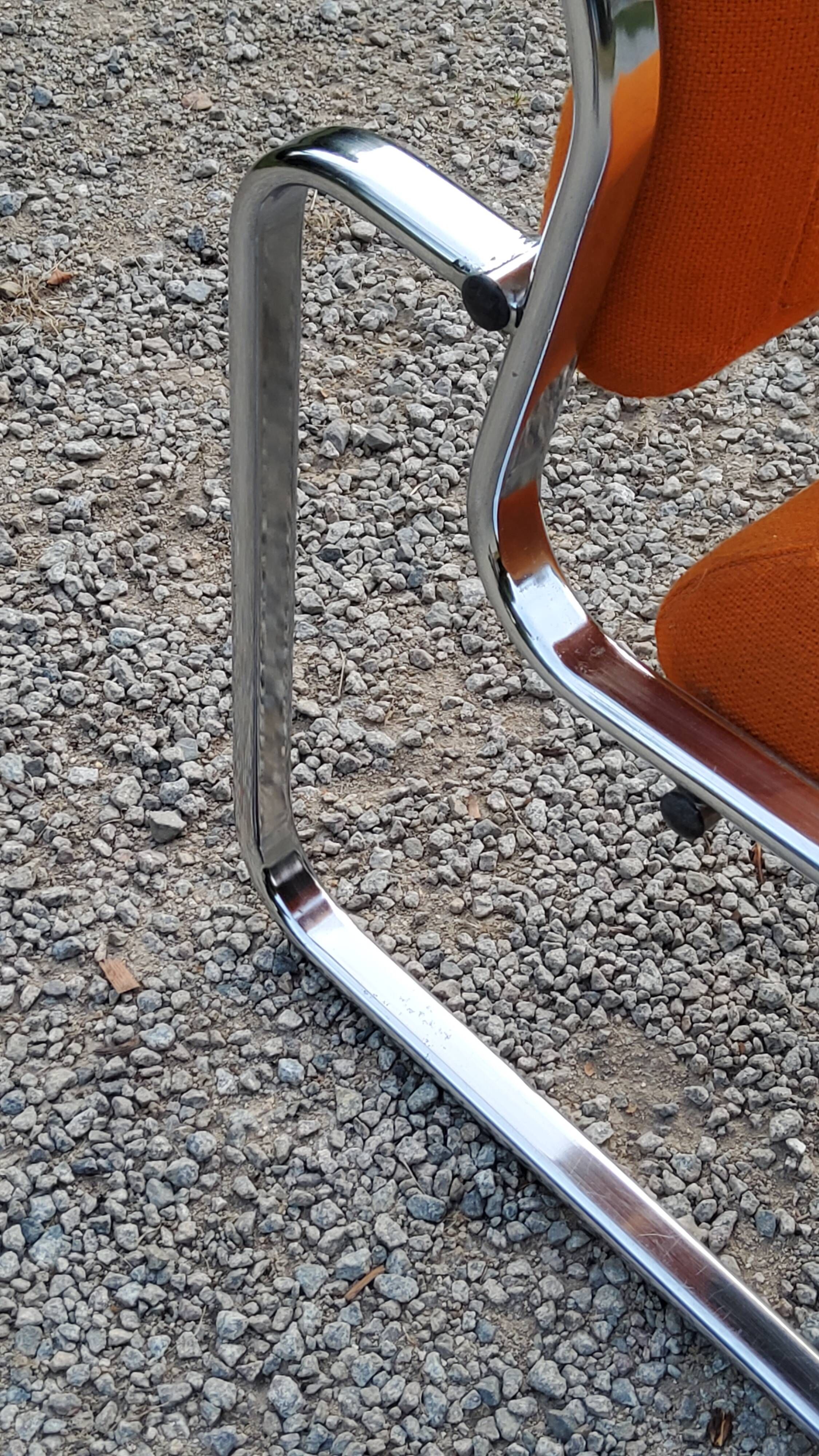 Pair of designer armchairs in orange fabrics and chrome tubes from the 70s