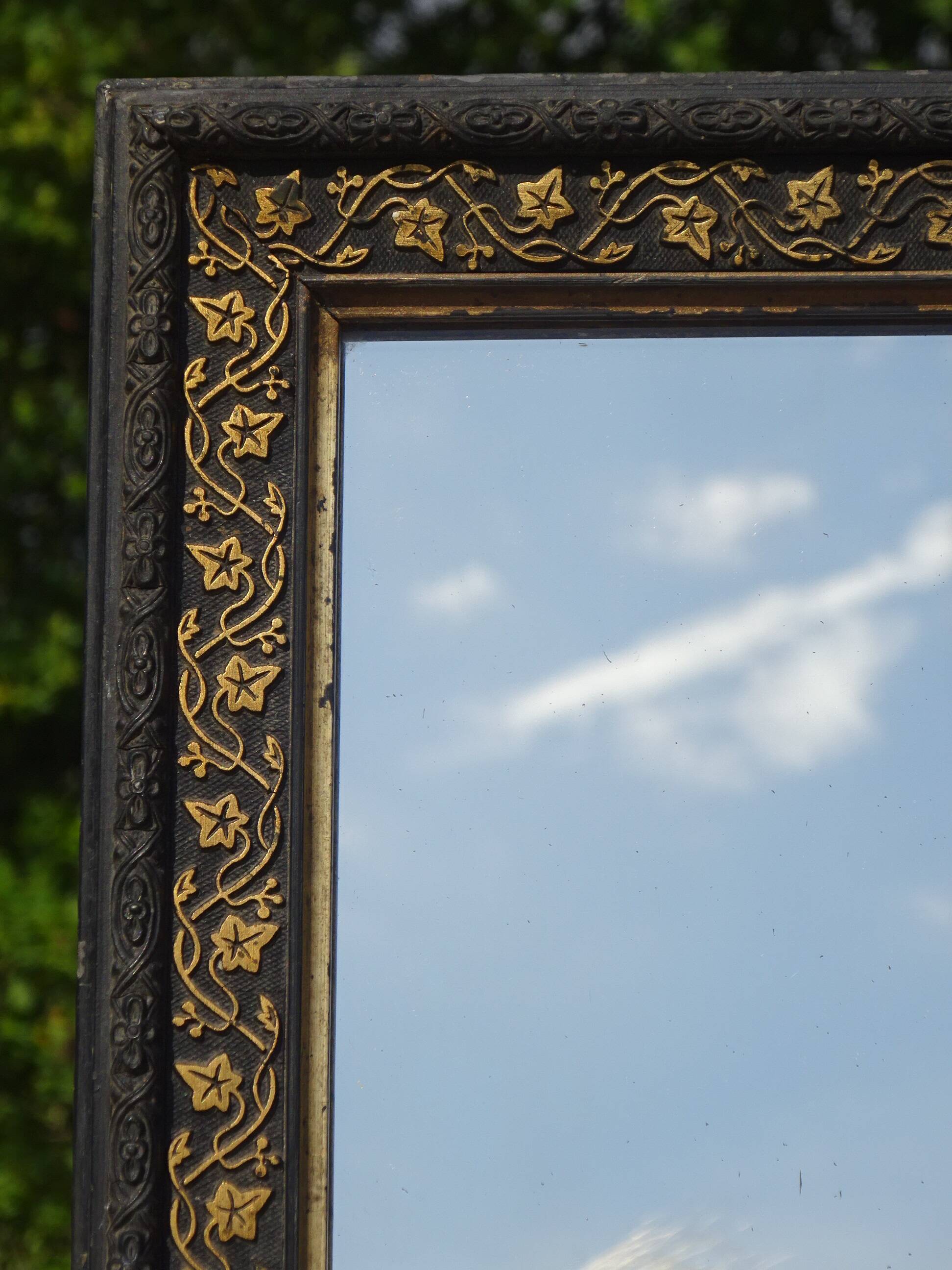 Mirror with black and gold frame, embossed vine leaves