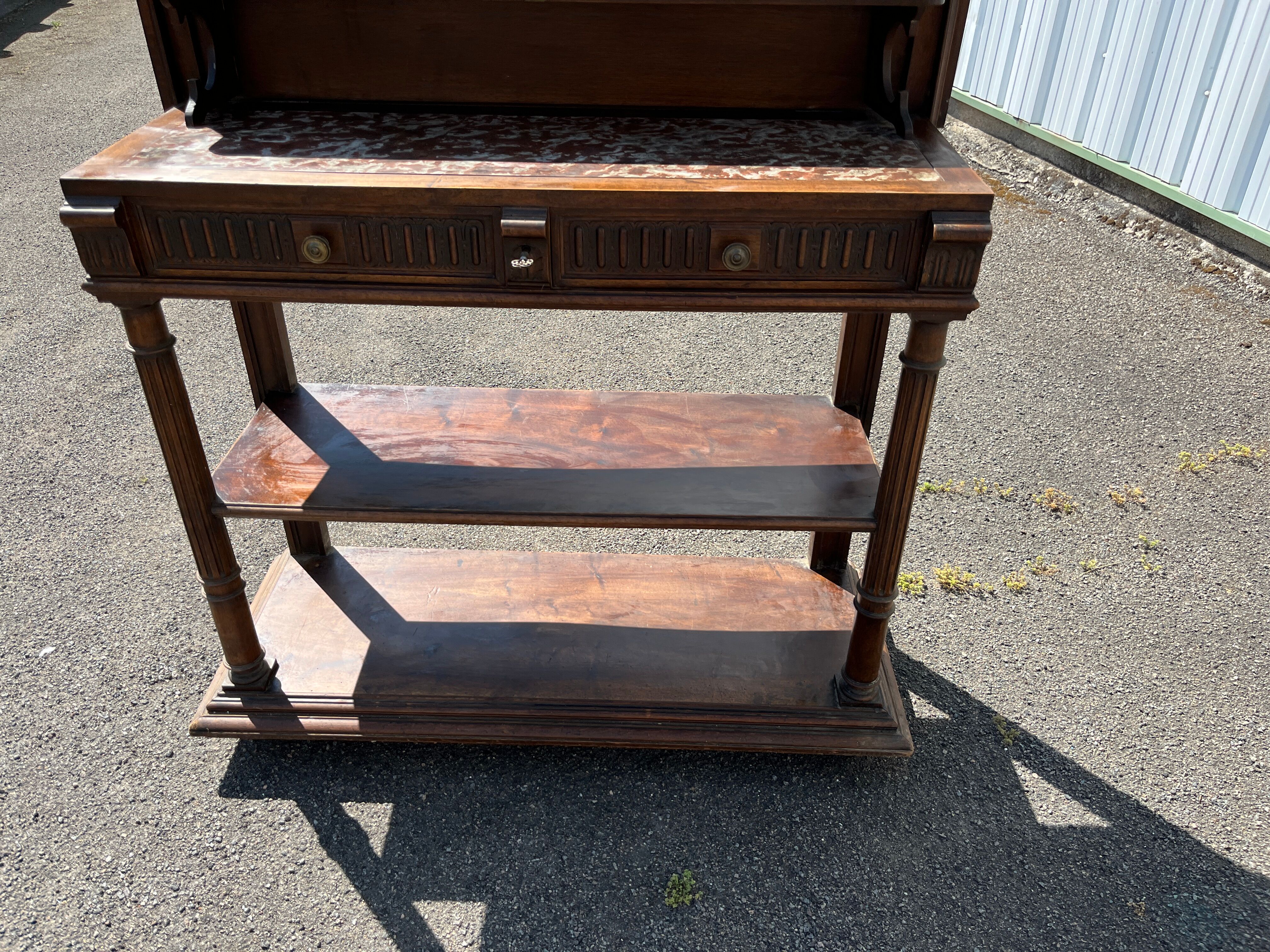 Carved wooden console table with three shelves and drop-leaf flap