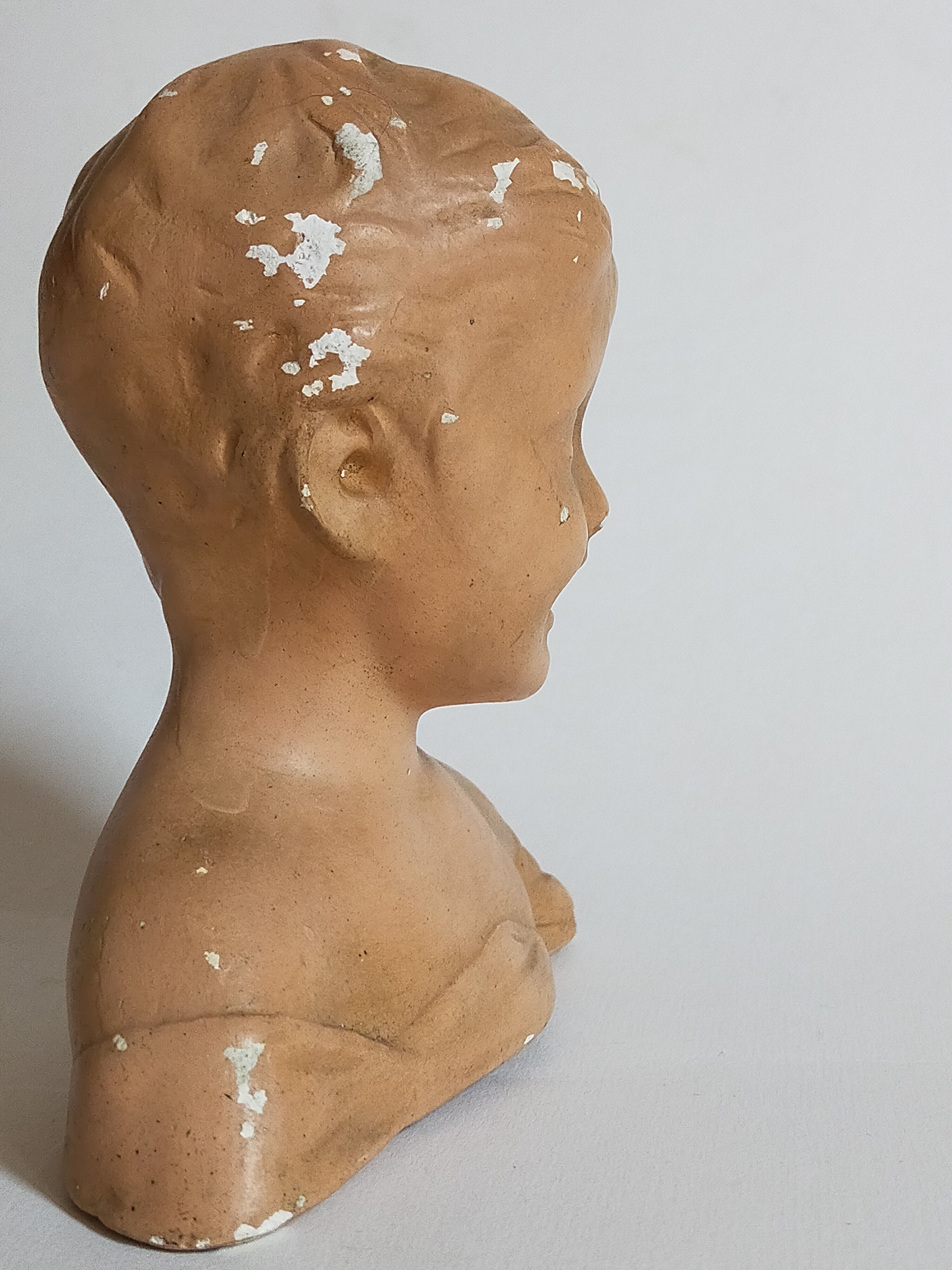 Bust of a small child in ancient plaster