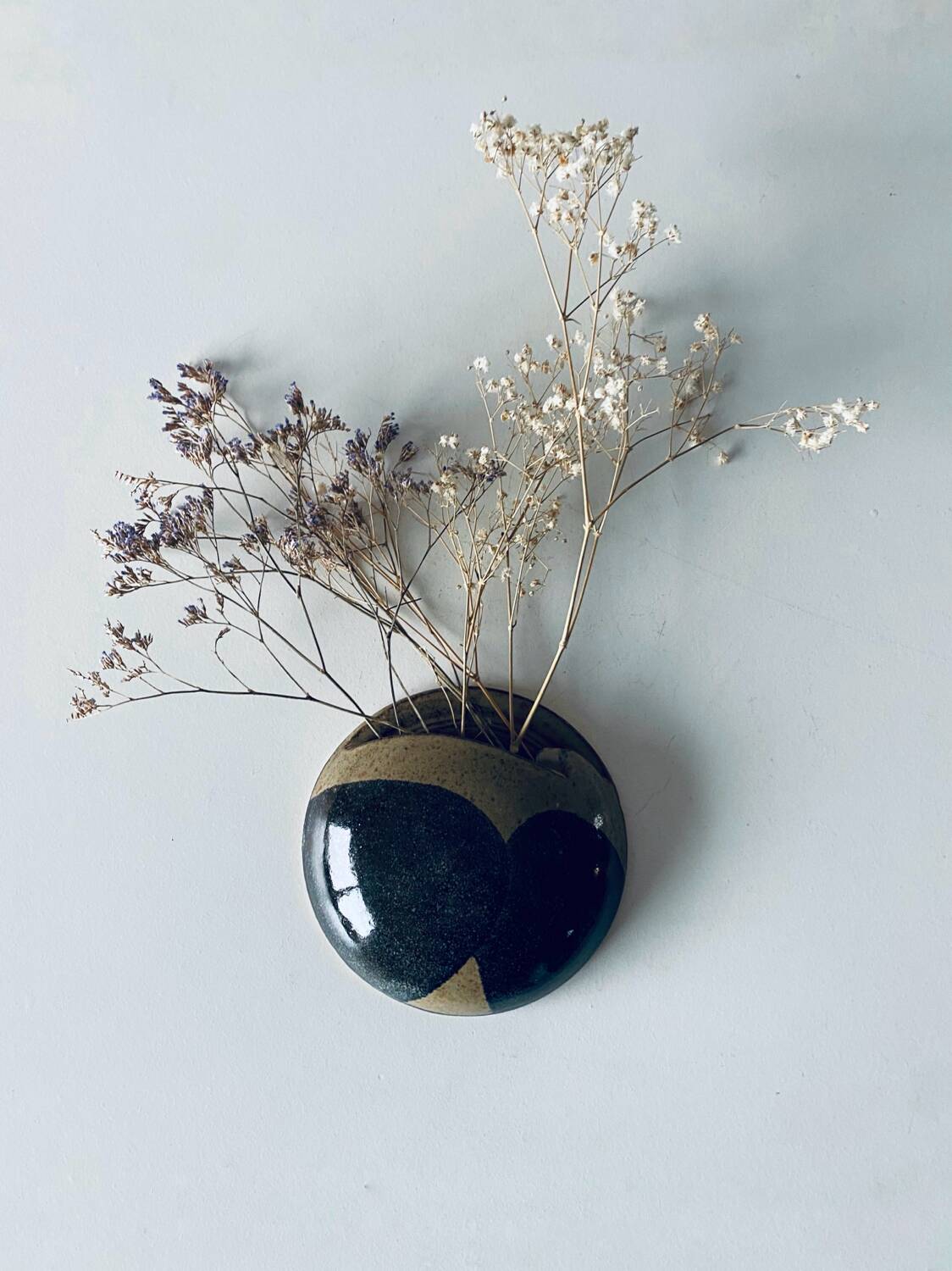 Lens-shaped wall vase