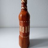 Vintage glass bottle covered with light brown leather and wicker