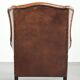 Sheepskin wingback armchair in a warm cognac colour with refined nailhead trim