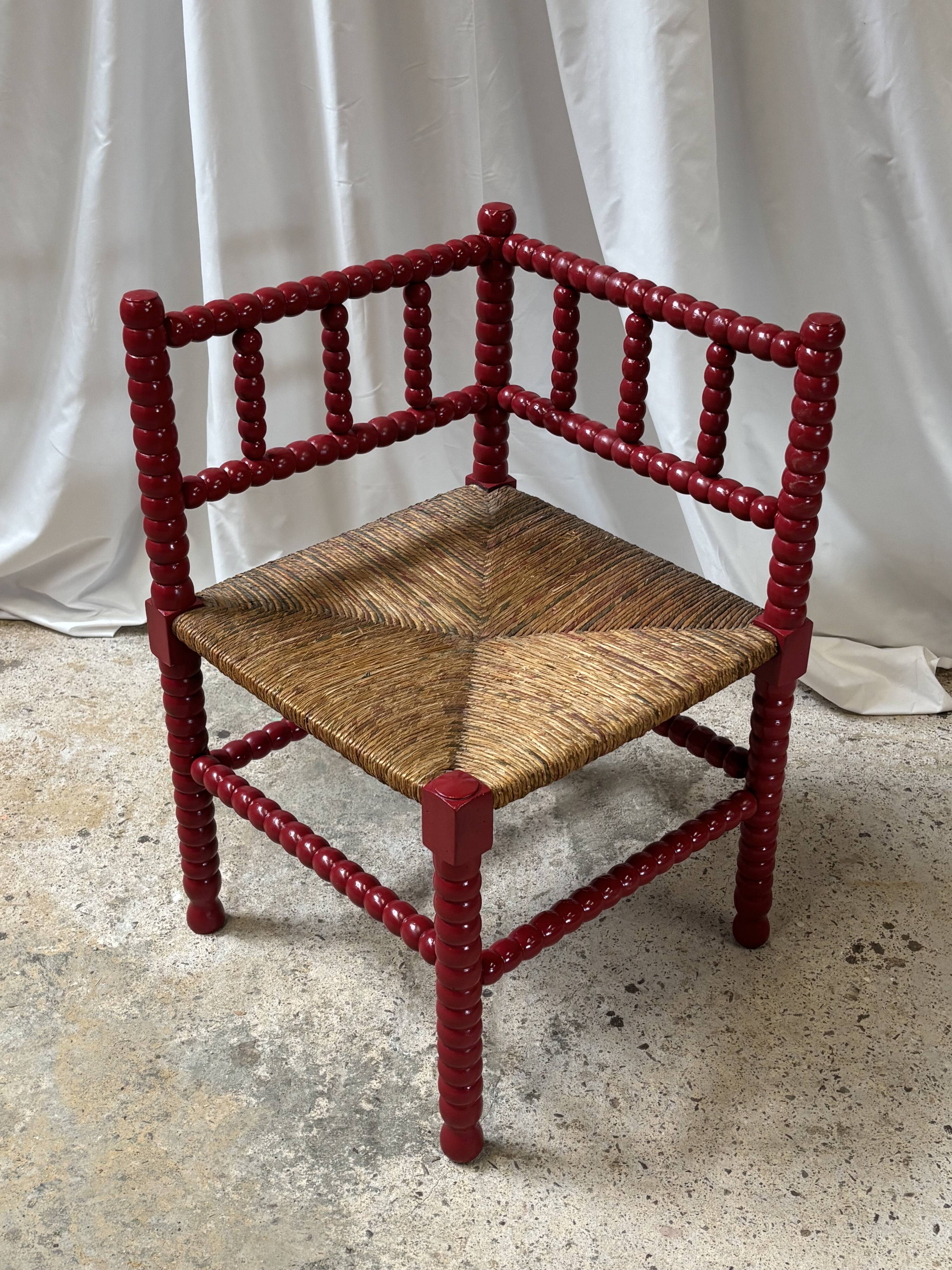 Red turned wood corner chair with rush seating