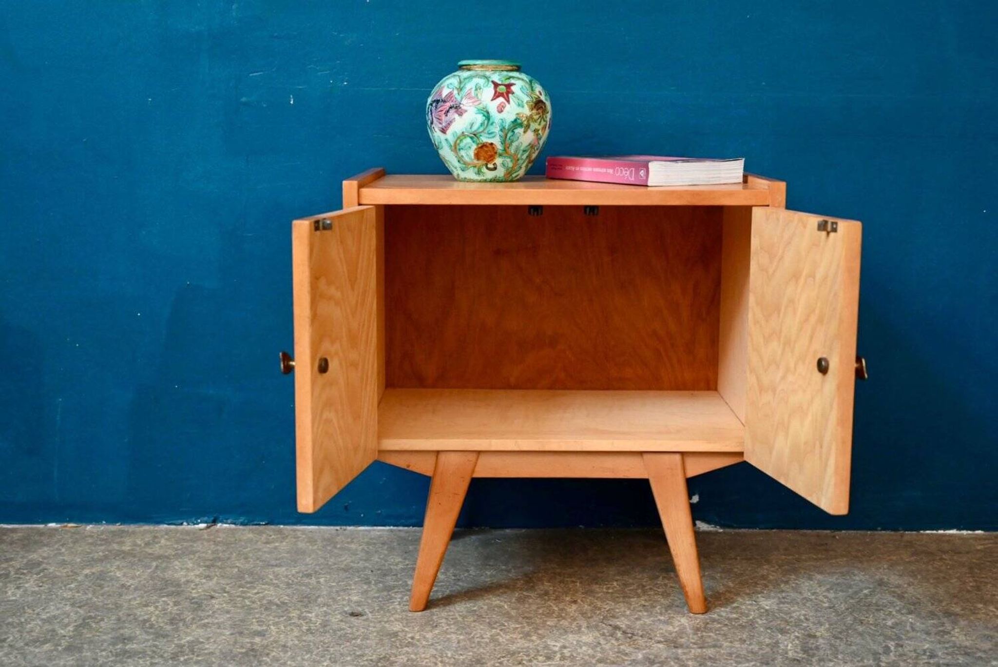 Rockabilly design bedside table with tapered legs.