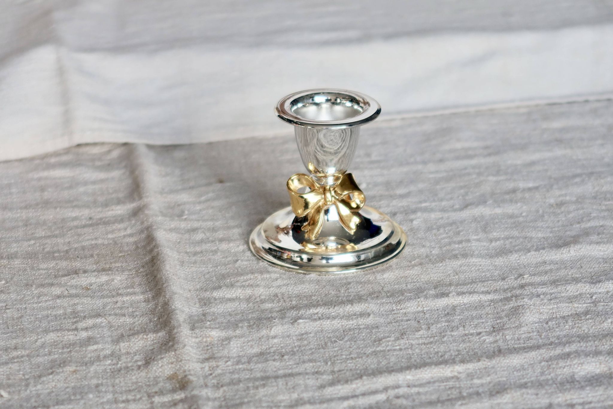 Small vintage silver-plated metal candlestick with a gold bow