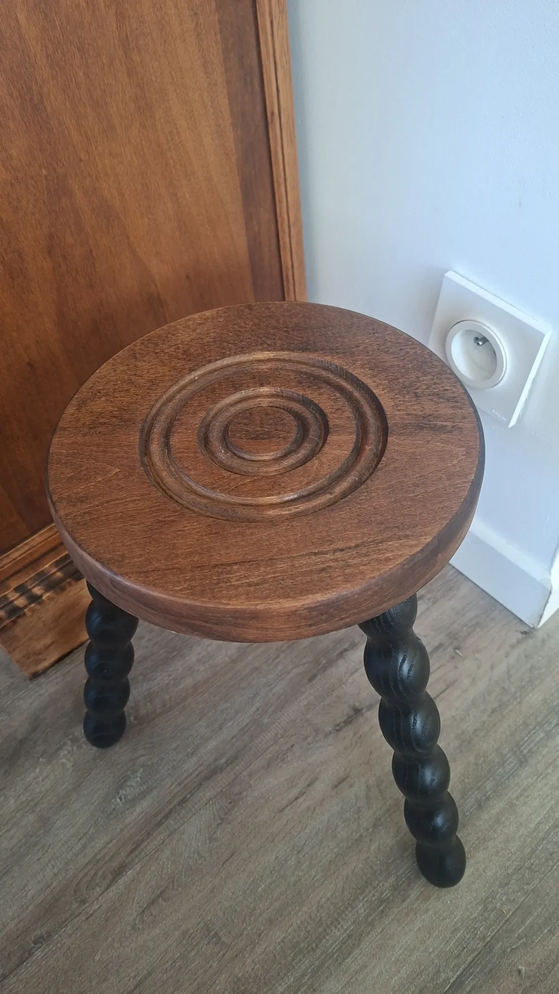 Brown and black wooden tripod stool