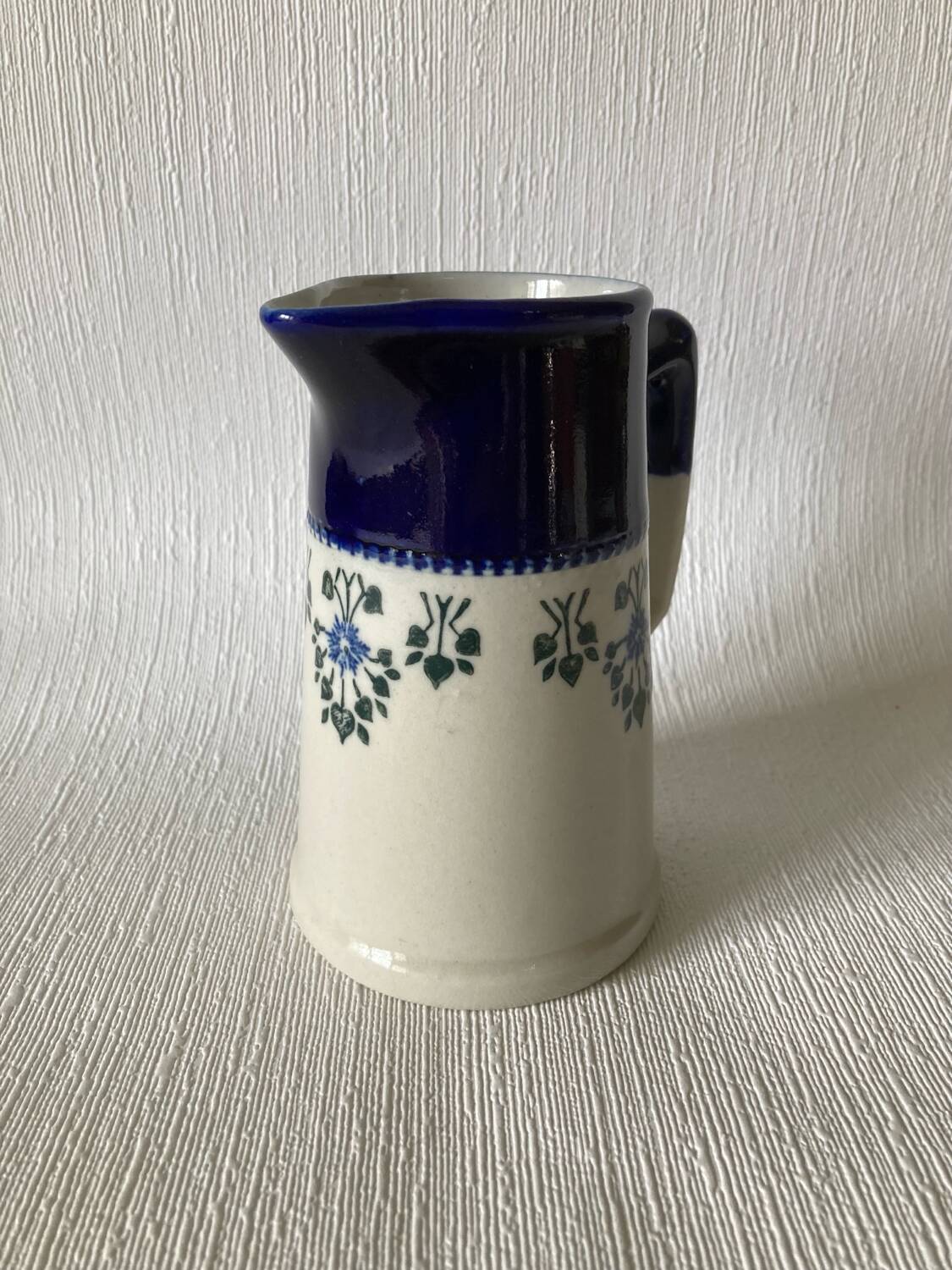 Pichet Saint-Uze en terre d’acier bleu, blanc et à décor floral