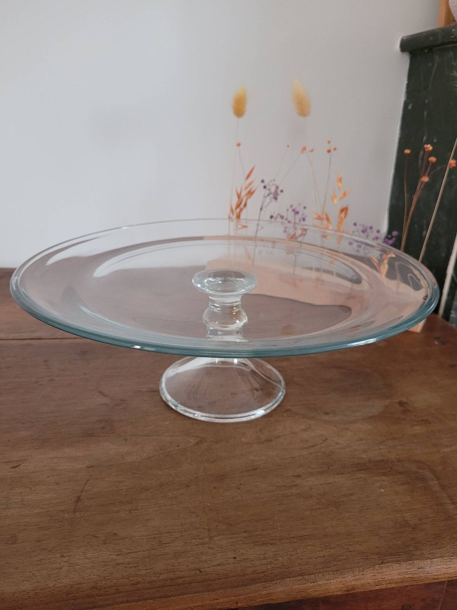 Large glass display plate mounted on a stand.