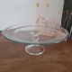 Large glass display plate mounted on a stand.