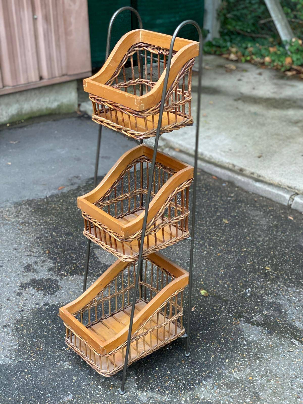 Woven rattan and steel display shelf in the shape of a staircase.