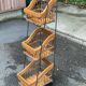 Woven rattan and steel display shelf in the shape of a staircase.