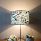 Table lamp with chrome stem, tropical plant shade.