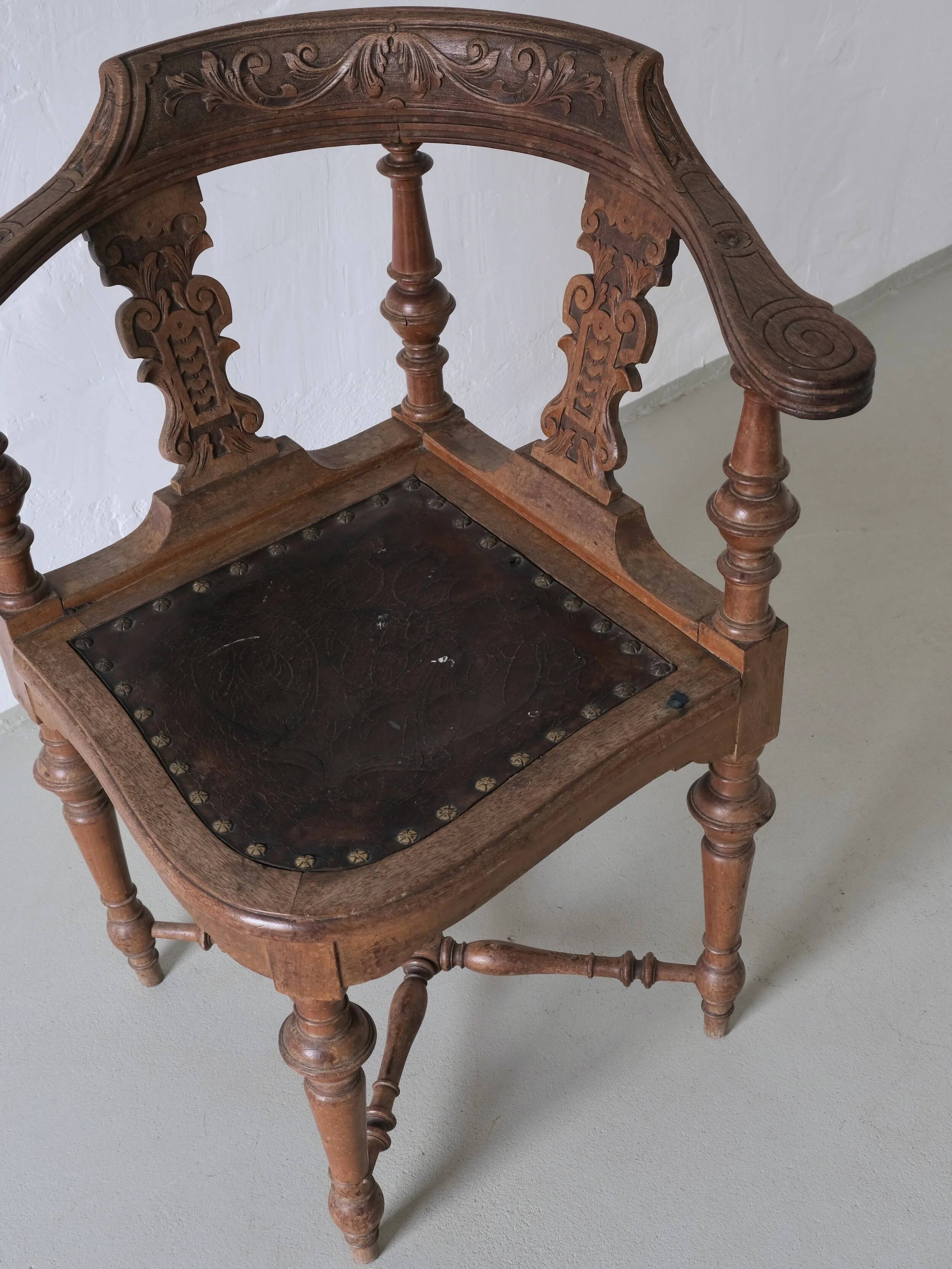 Fauteuil d'angle ancien sculpté avec assise en cuir