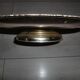 Large silver metal tray raised by a central foot
