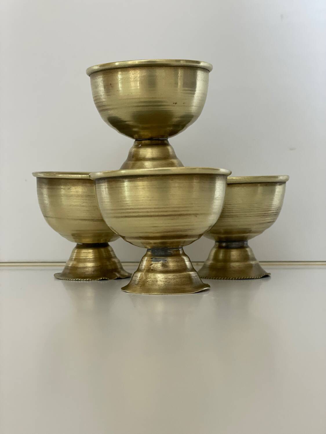 4 golden brass egg cups