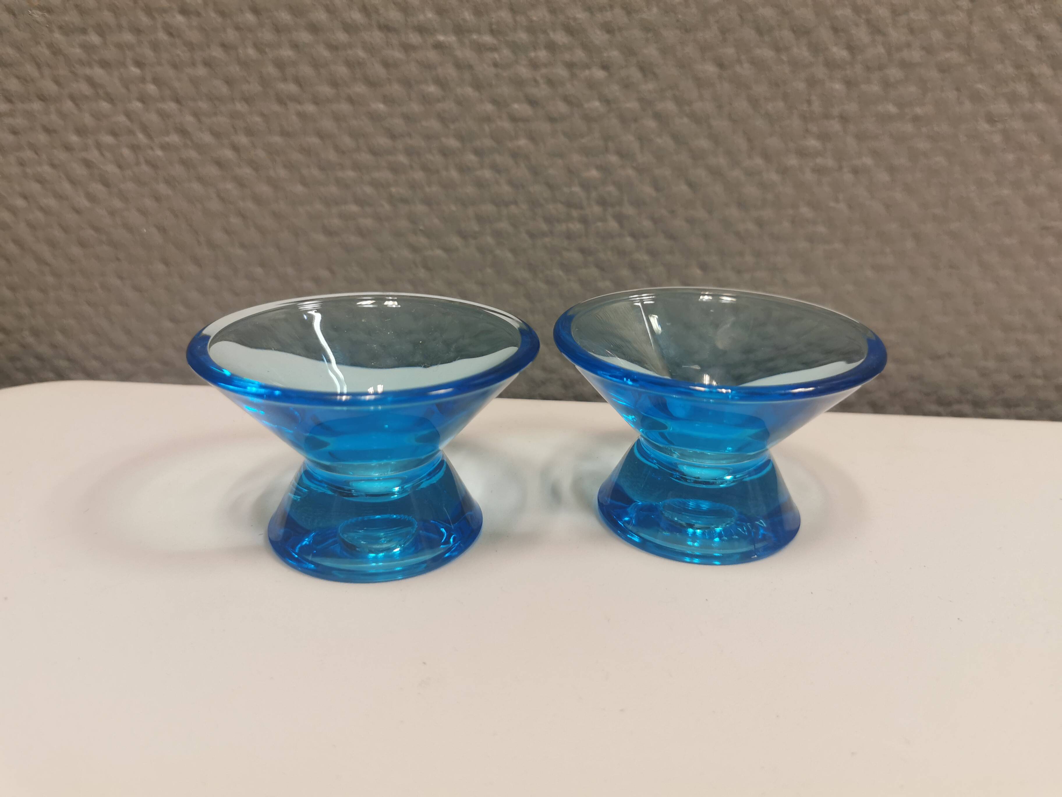 Two small candle holders in blue glass from the well-known Finnish company Ittala.