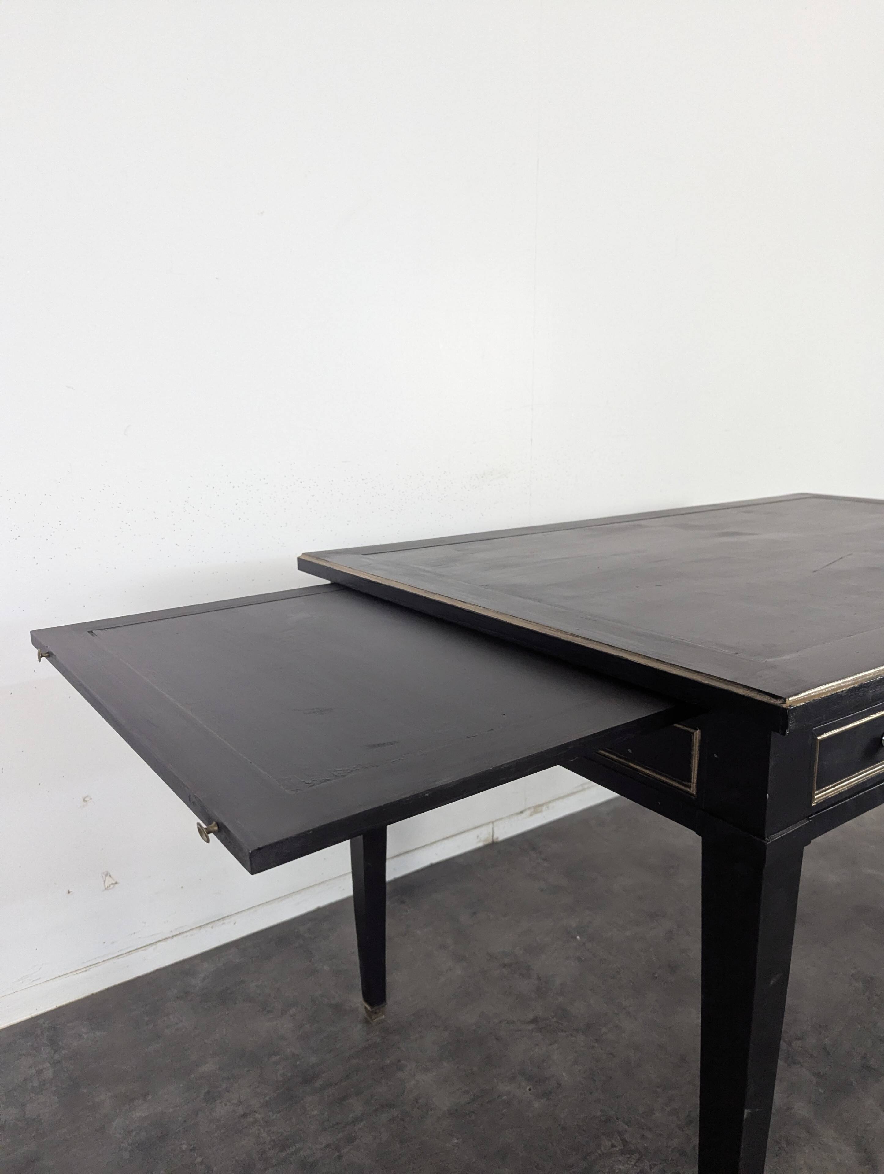 Large flat desk in Louis XVI style, black lacquered with gold highlights.