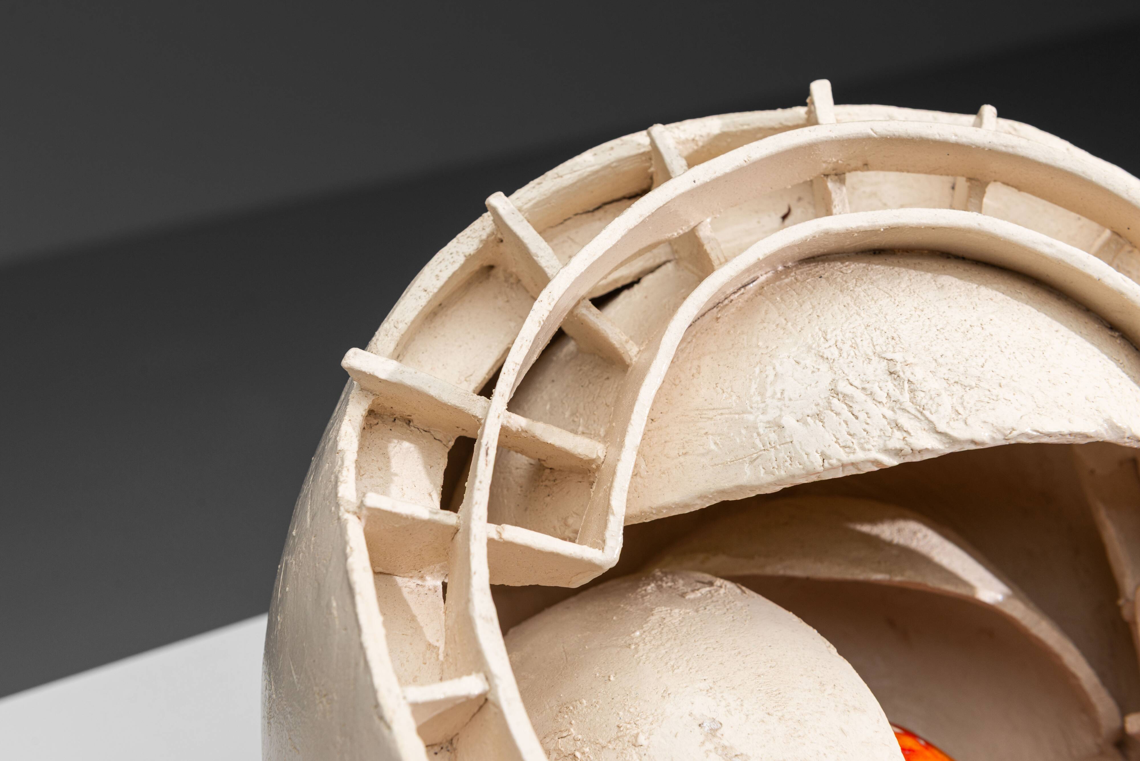 Sculpture en céramique abstraite avec un noyau orange.