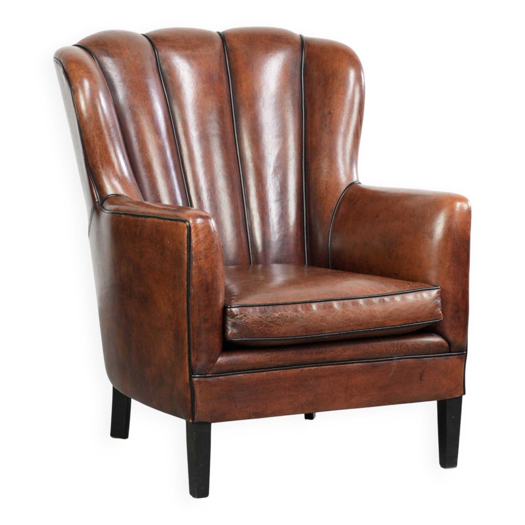 Fauteuil en peau de mouton confortable au design unique, fini avec un passepoil noir.