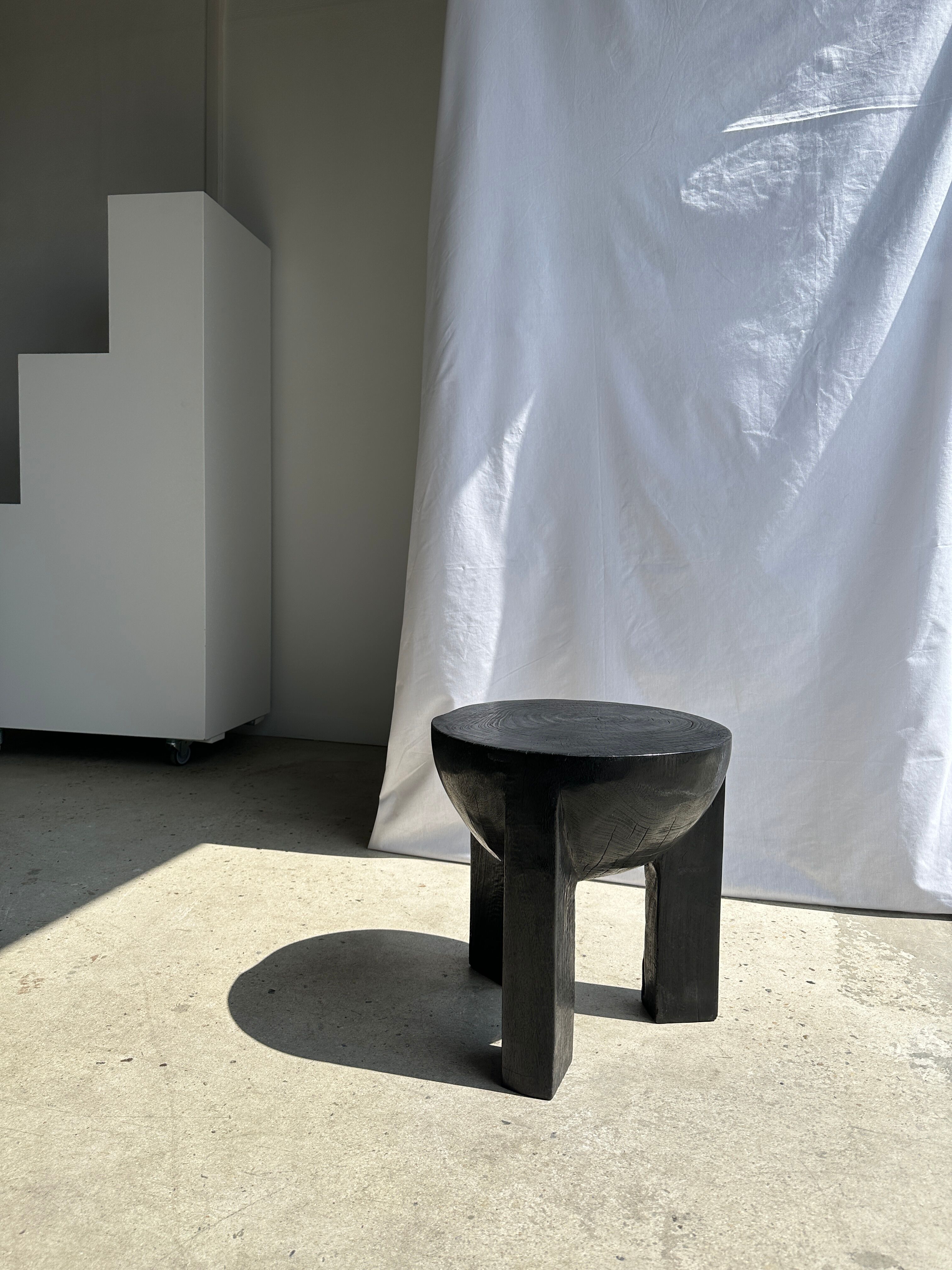 Black mango wood tripod side table with a semi-spherical top, height: 45 cm, diameter: 44 cm.