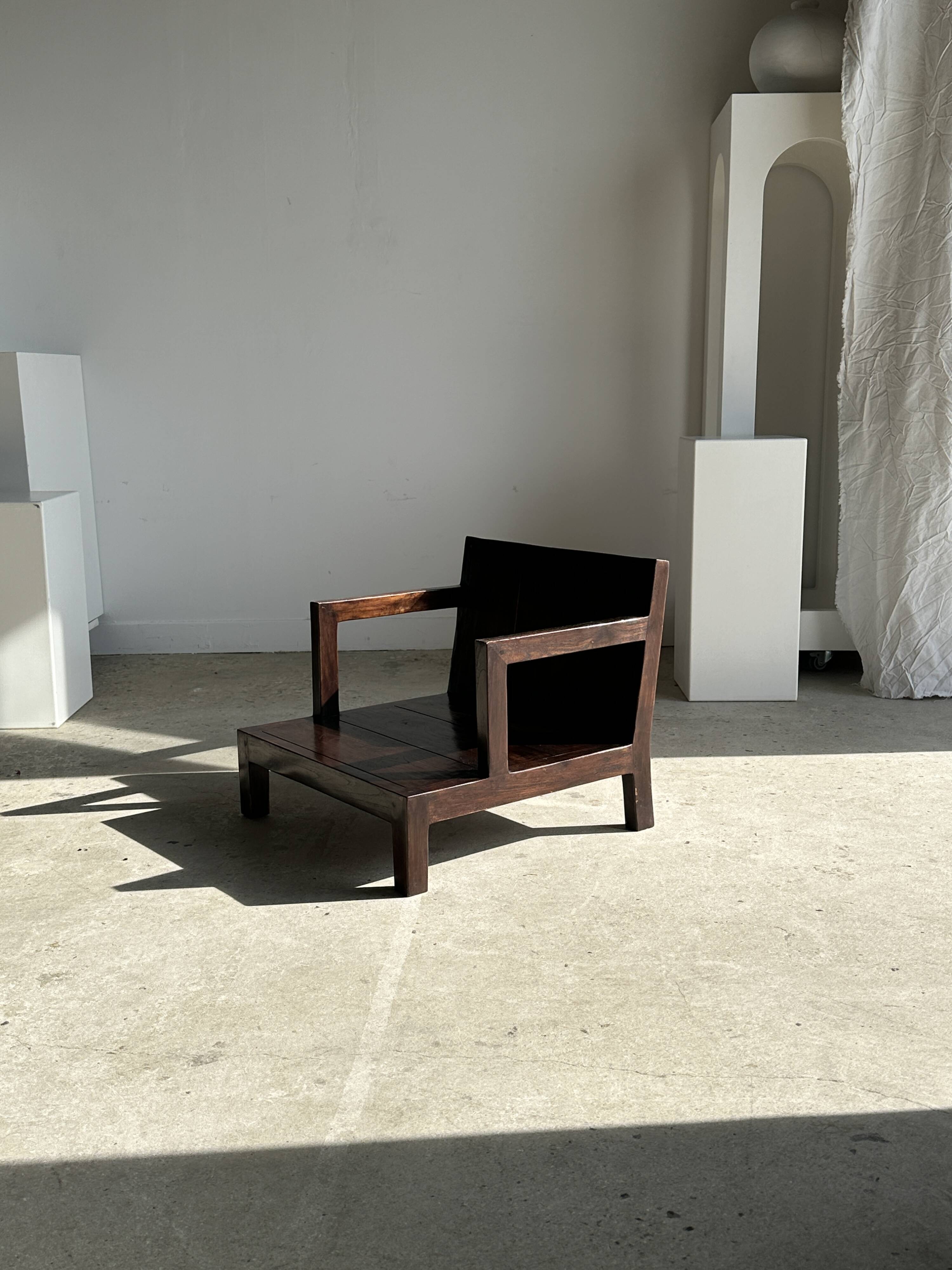 Small low armchair in varnished brown wood