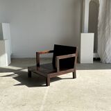 Small low armchair in varnished brown wood