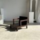 Small low armchair in varnished brown wood
