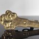 Vintage brass coat hook with marine creature motif and medallion.