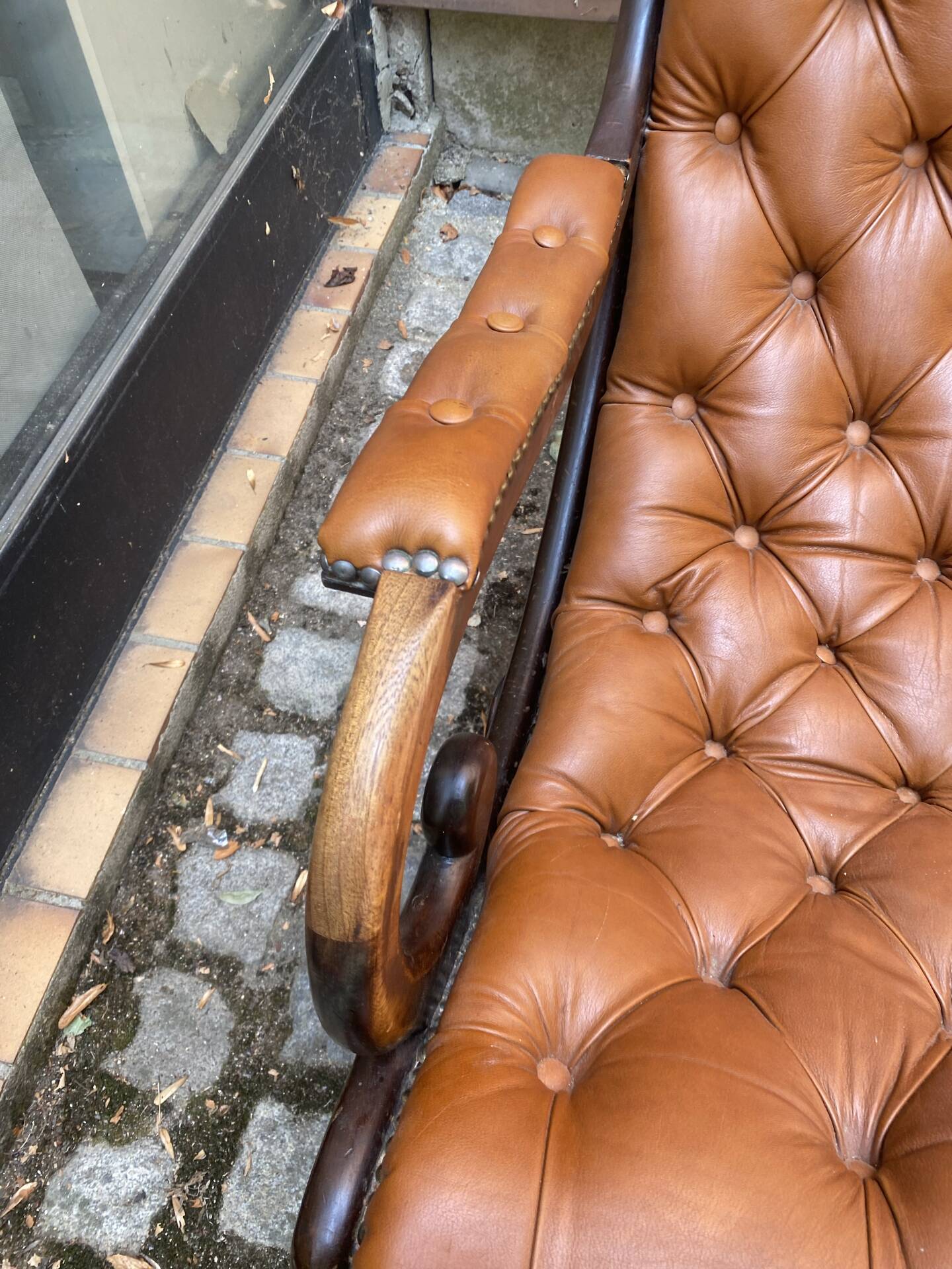 Chesterfield armchair in leather and carved solid wood