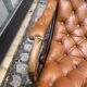 Chesterfield armchair in leather and carved solid wood