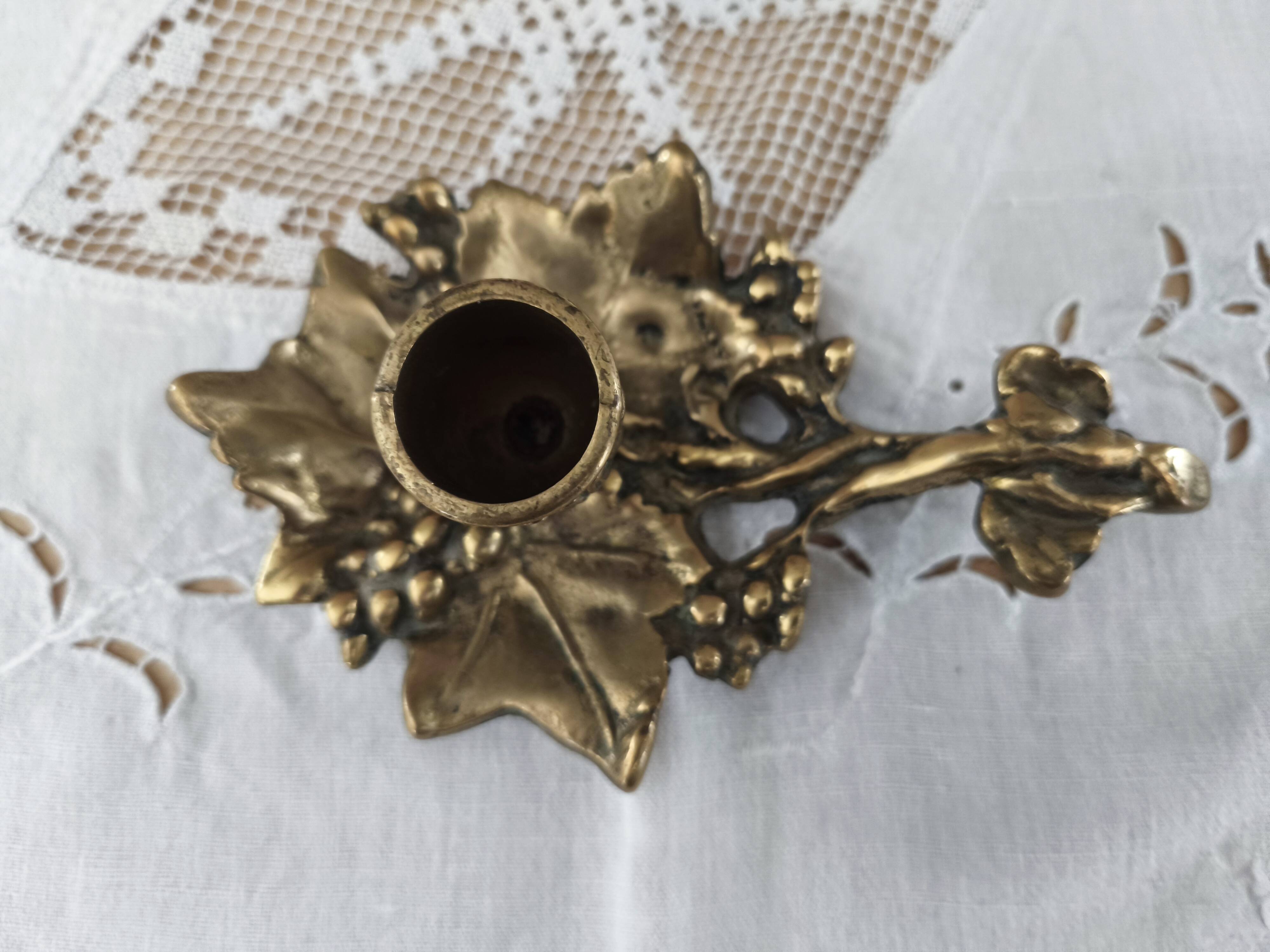 Hand-held candle holder called "cellar rat" in brass with vine leaf decoration
