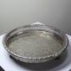 Small Moroccan tripod tea tray in silver-plated metal, vintage chiseled decoration.