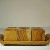 Six egg cups on a wooden tray.