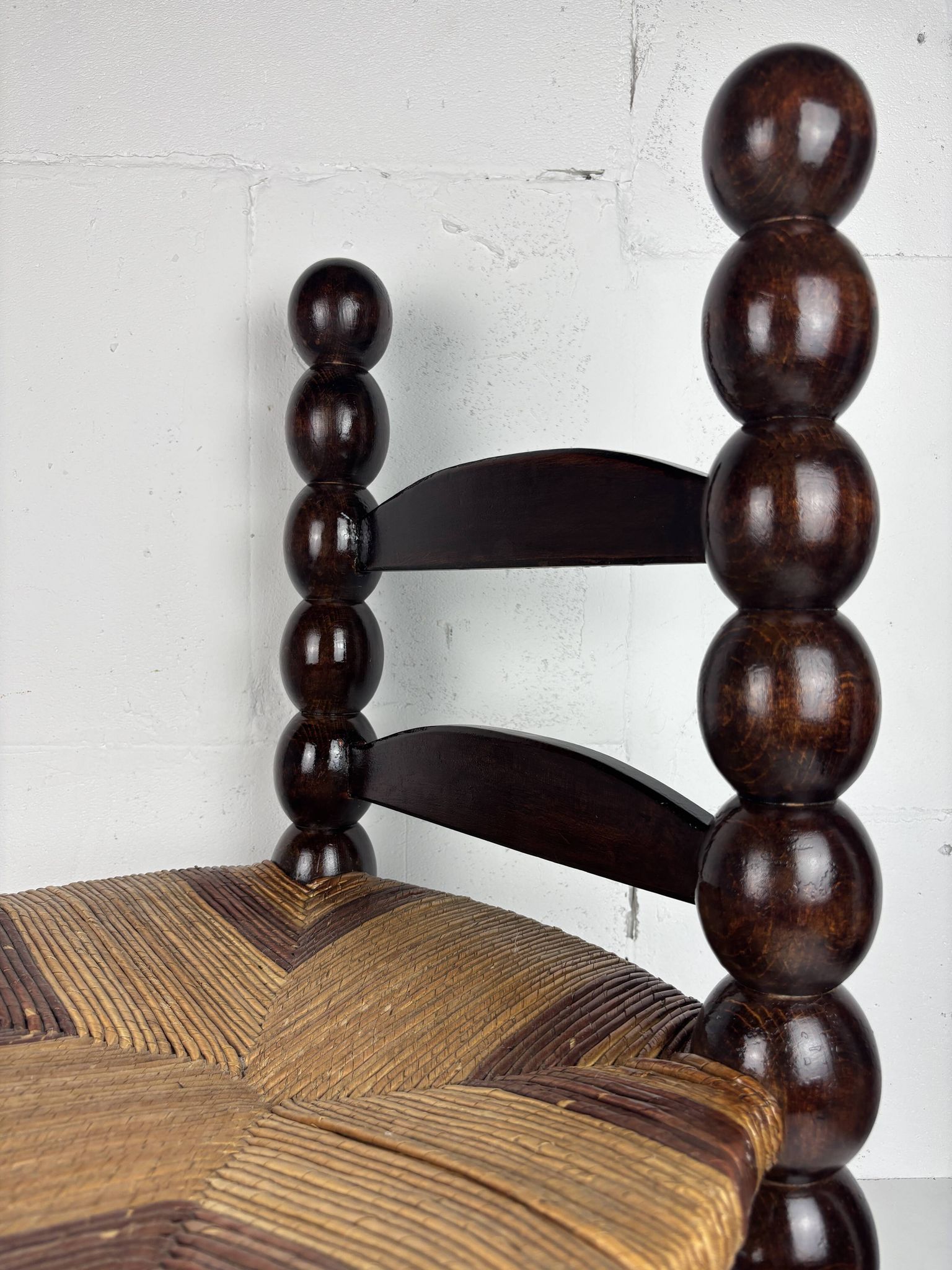 Brutalist wood turned bobbin low rush chair n the style of Charles Dudouyt