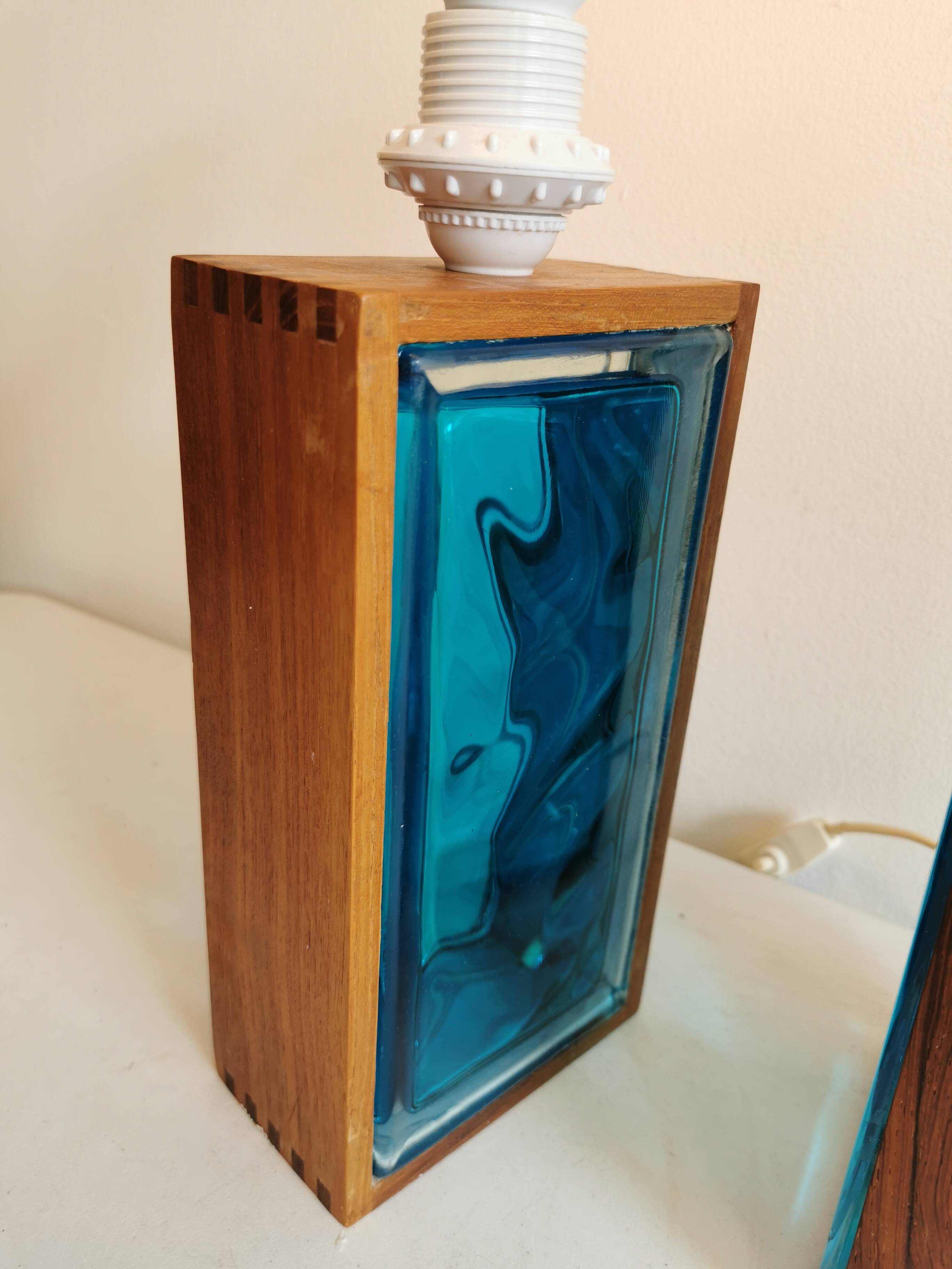 Two Swedish table lamps in solid pressed blue glass and teak wood "frame".