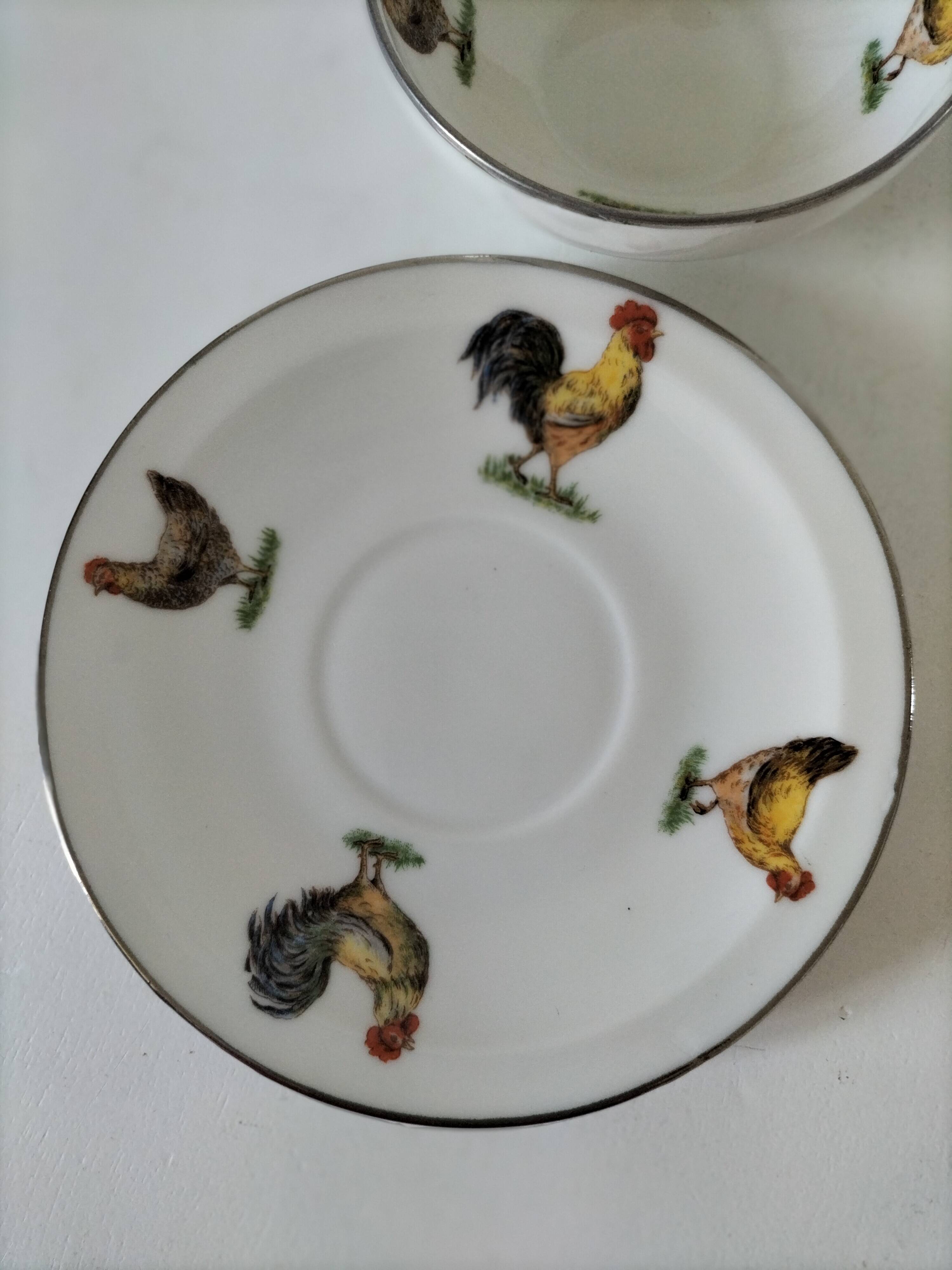Cup and saucer in porcelain decorated with roosters and hens.