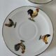 Cup and saucer in porcelain decorated with roosters and hens.