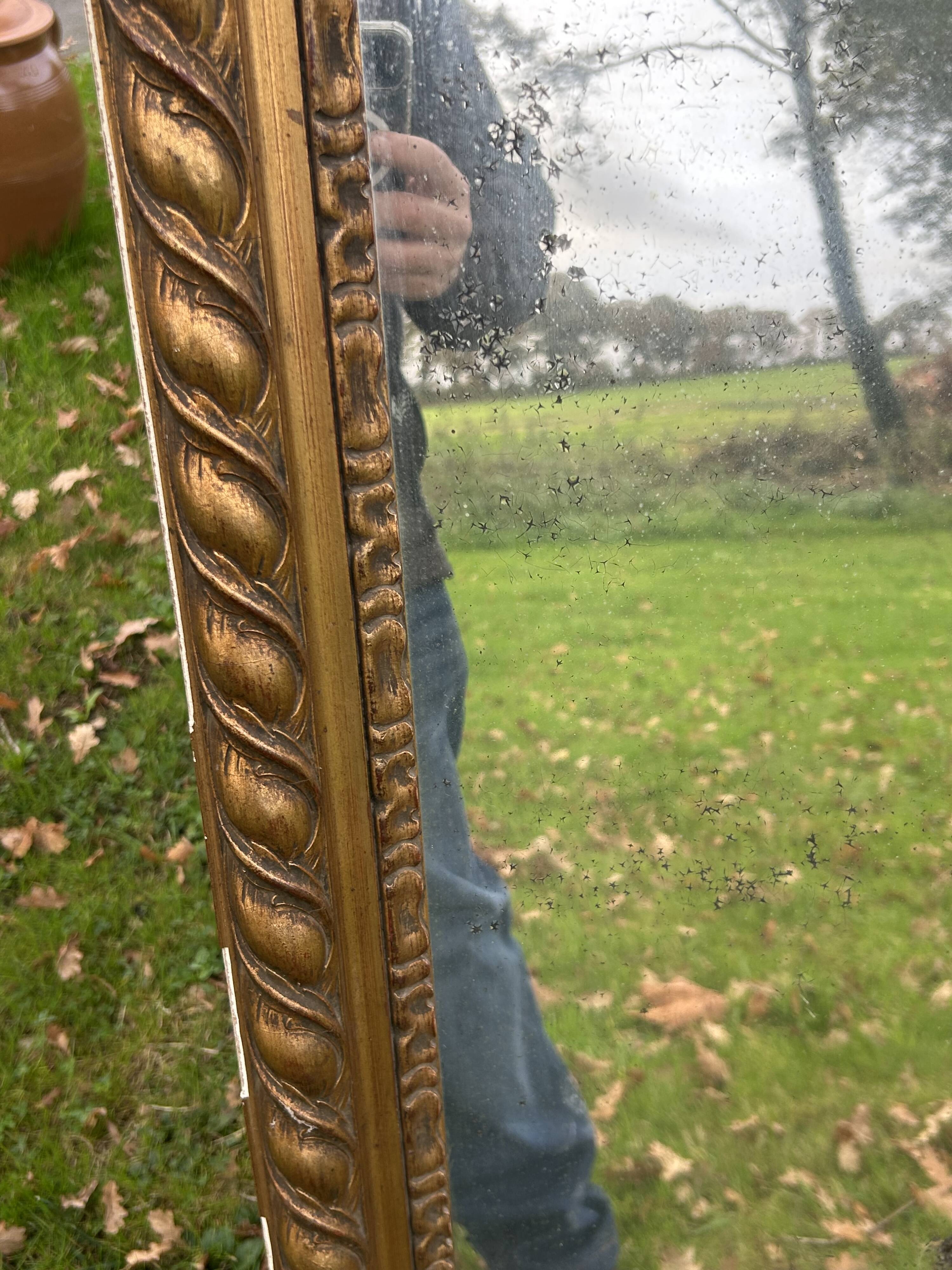 Large antique gilded mirror, wood and stucco gadroons, partially de-mercury