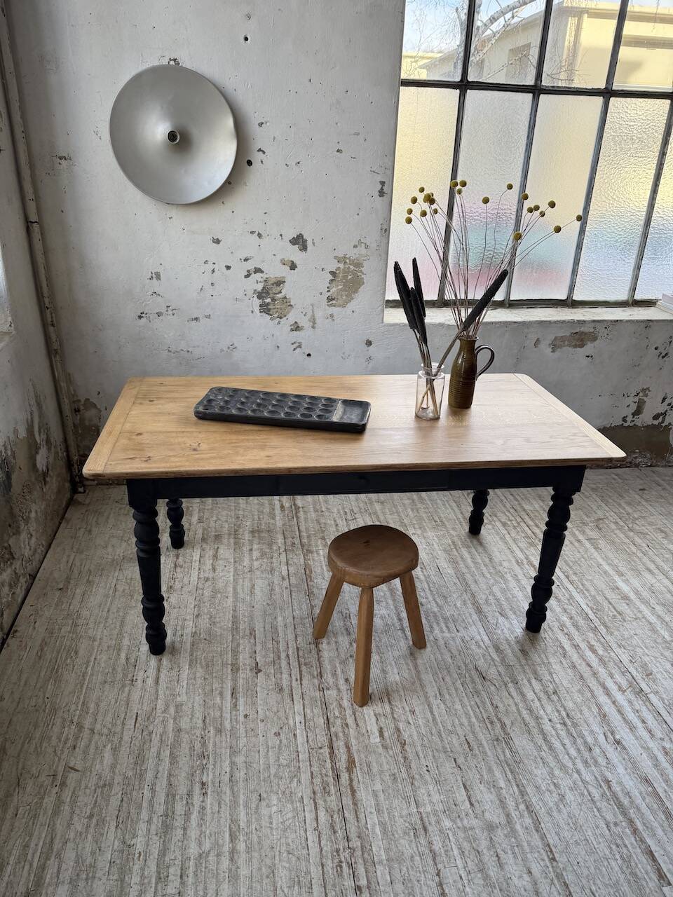 Oak farmhouse table with turned black legs.