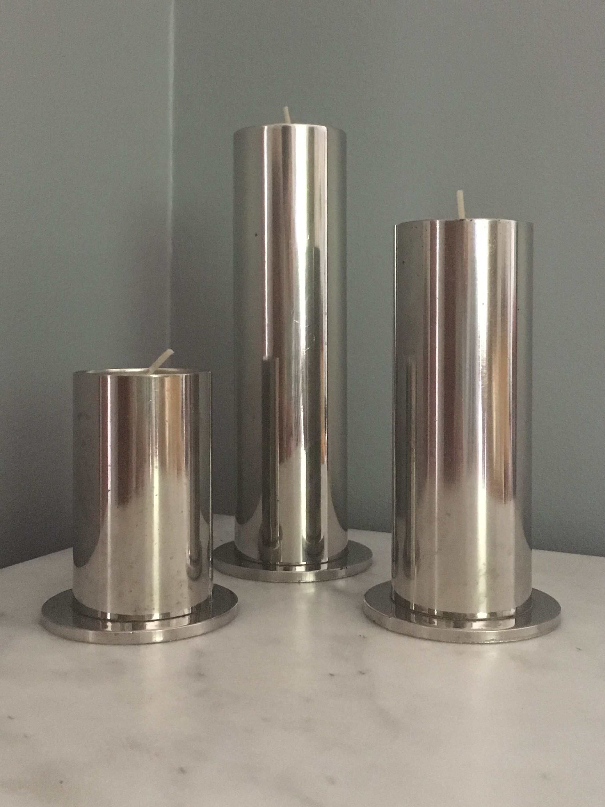 Suite of three brushed steel candlesticks from the 1970s