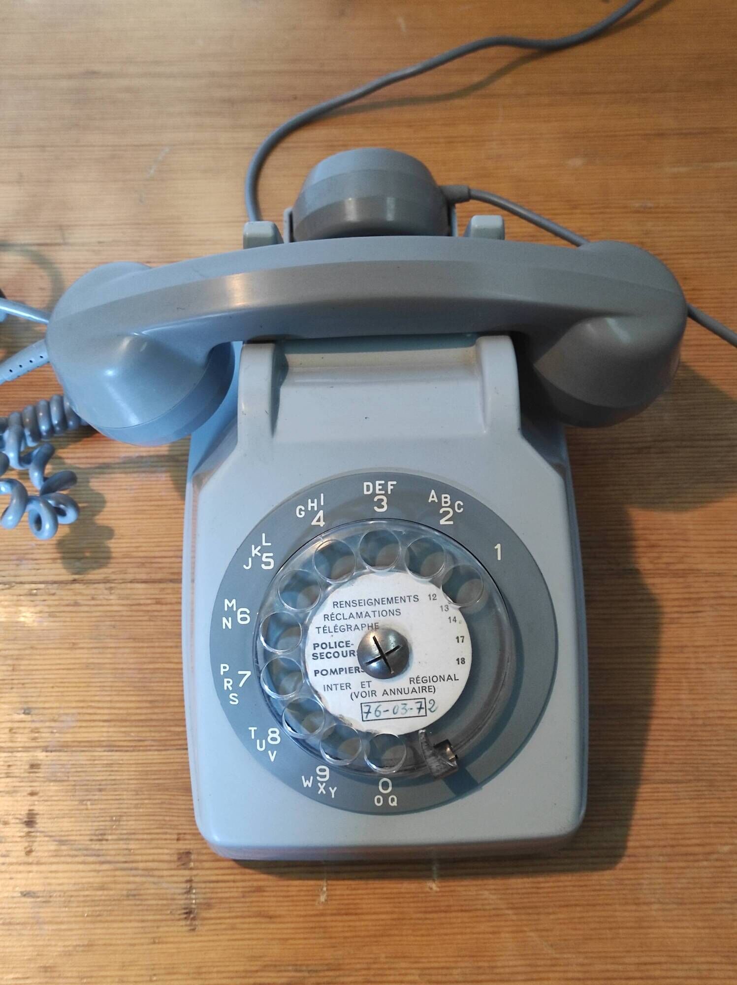 Old vintage wired dial phone with its earphone, gray color. Late 70s - early