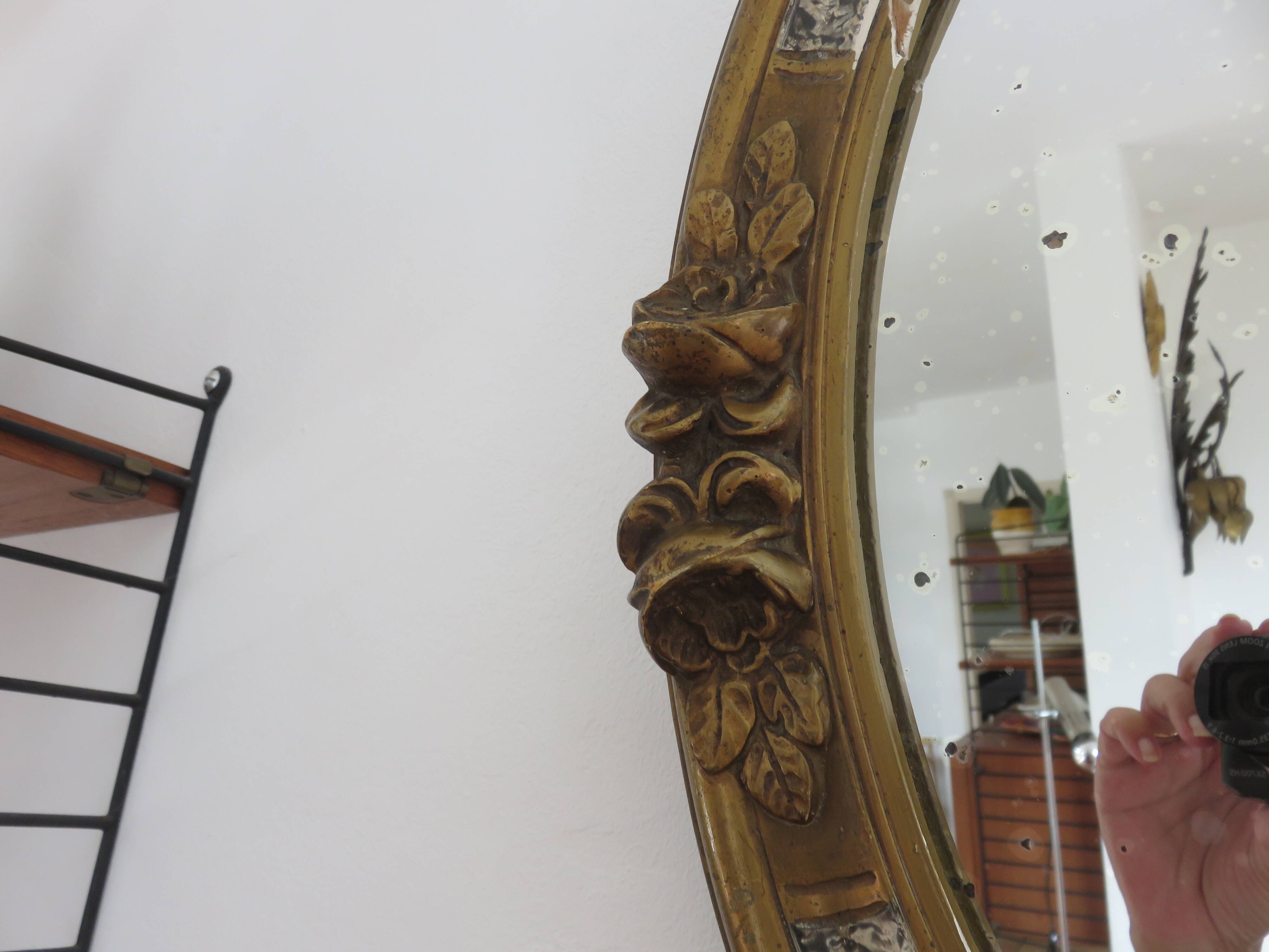 Oval wall mirror, golden floral pattern in stucco and wood, late 19th century