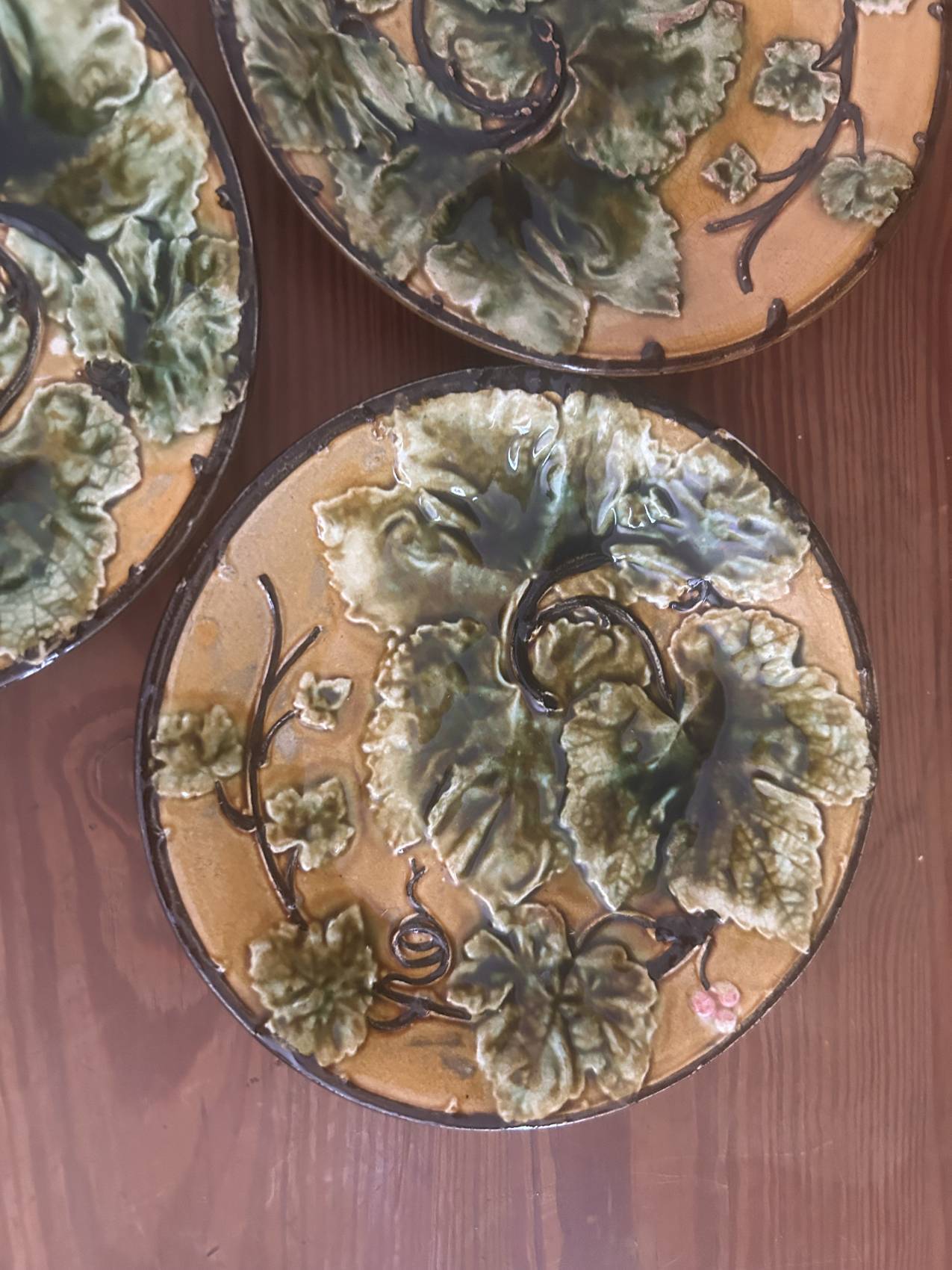 Four antique dessert plates in majolica with vine decoration.