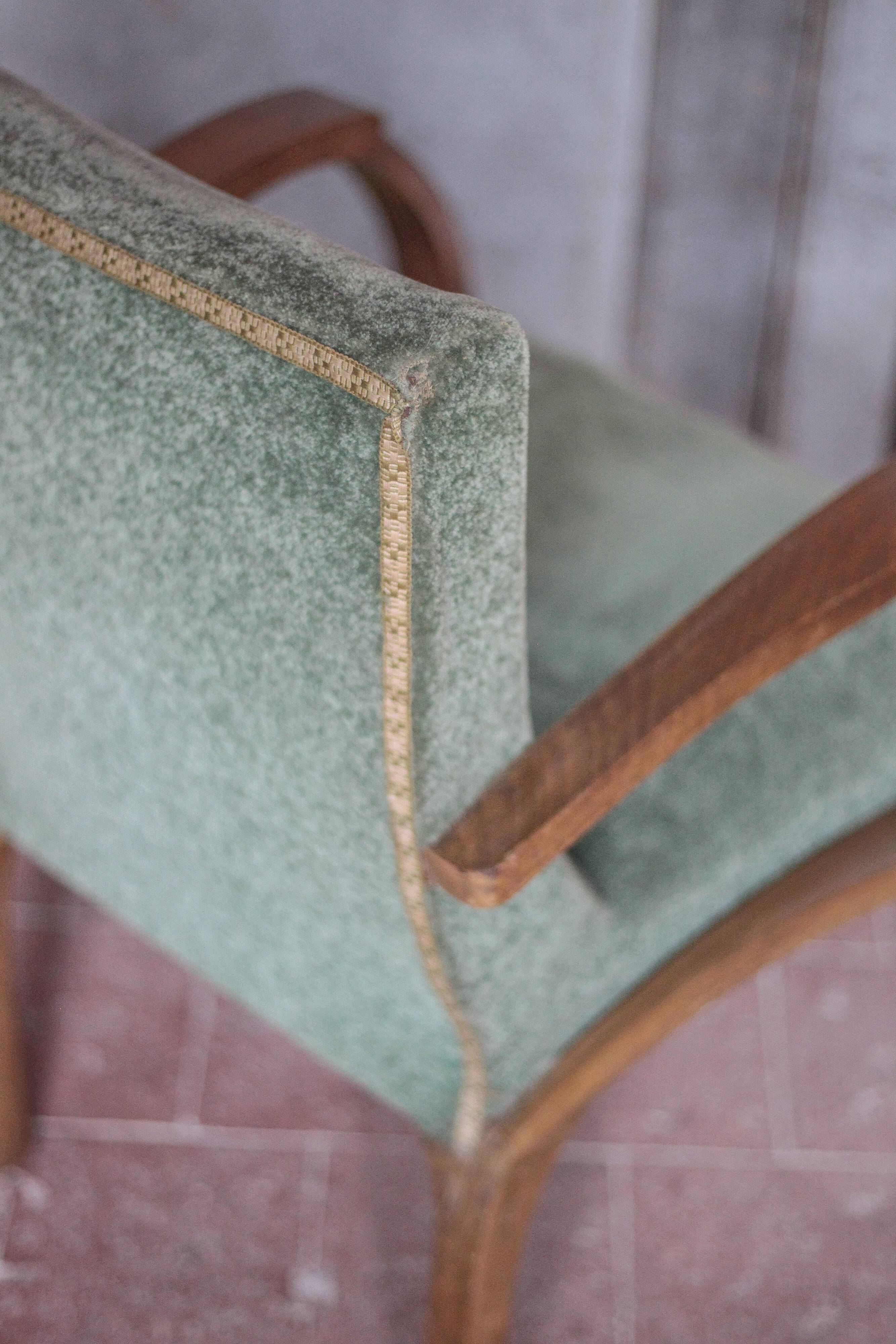 Art Deco armchair in wood and green fabric, living room armchair, interior decor.